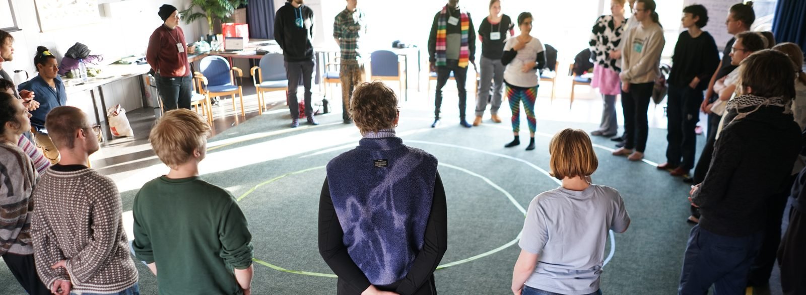 Participants standing in a circle during a lab exercise